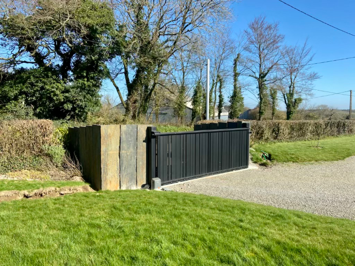 Portail coulissant avec habillage en ardoise à Guipronvel par Quéré Paysages